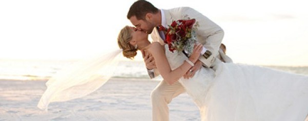 Newly Wed kissing on beach
